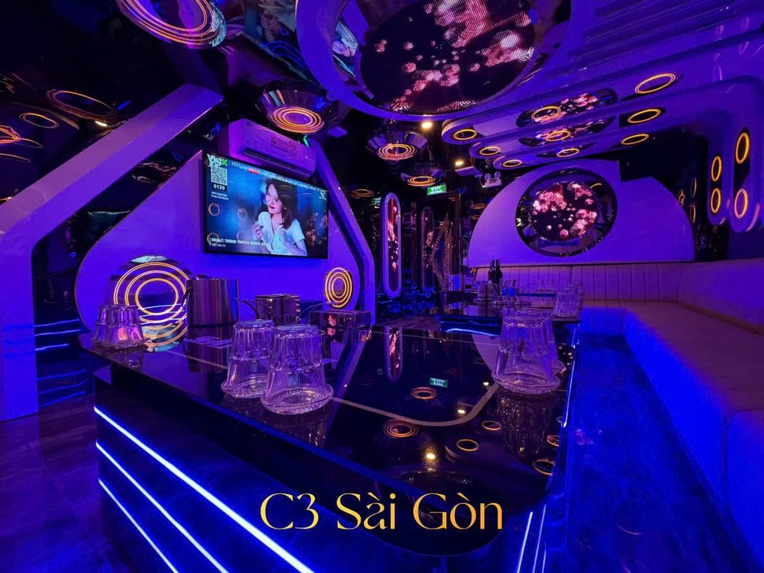C3 SÀI GÒN KTV 小房：黑鏡玻璃桌、燈帶底座與金色光圈裝飾