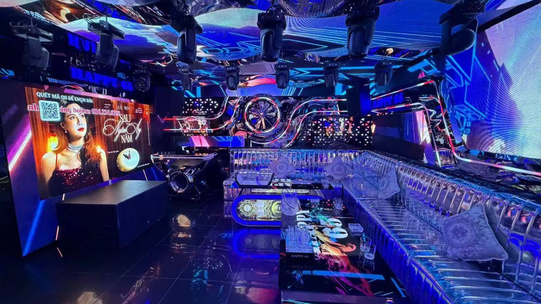 HAPPY 65 KTV 大包廂：天花整片 LED 屏配一排搖頭燈，側牆巨幅屏可掃碼點歌，銀色絎縫長沙發