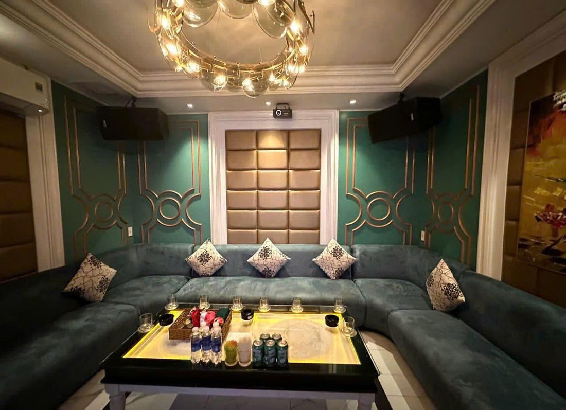 NEW 127 KTV 墨綠絲絨 U 型長卡座包廂，墨綠護牆板壓香檳金圓環線條與金色圓環水晶吊燈